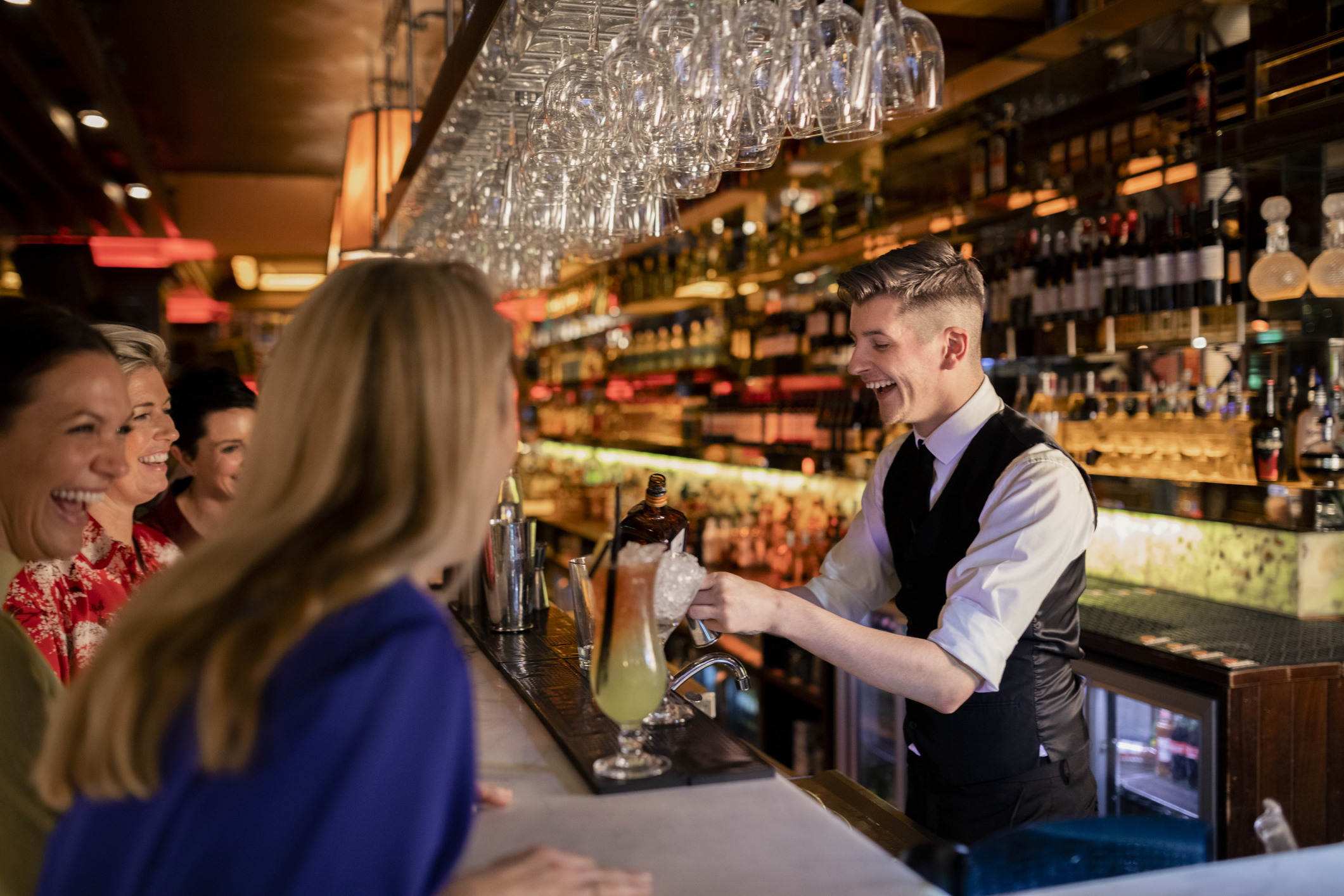 bartender serving customers at bar