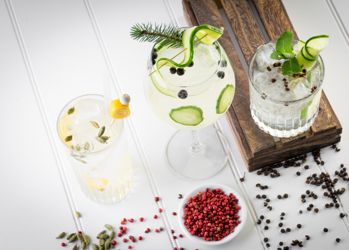 Tres cócteles de ginebra servidos en un día de verano con garnishes
