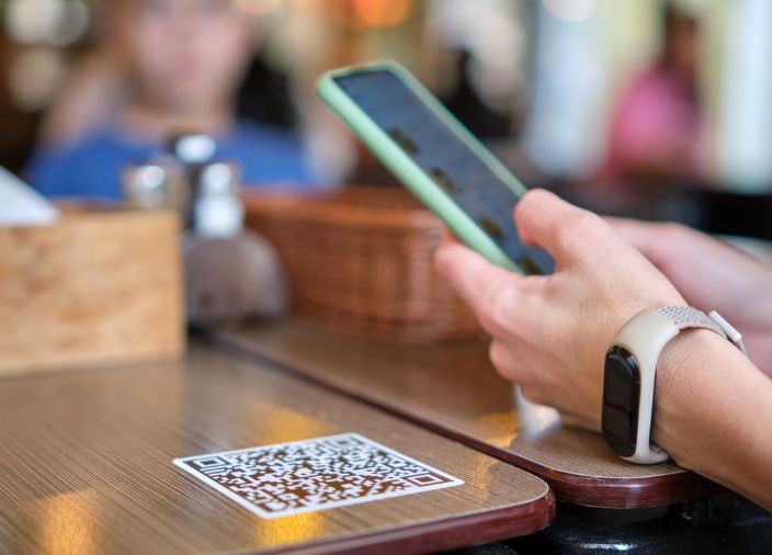 Customer looking at bar menu on their phone by using QR code