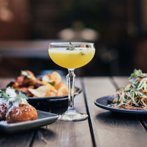 Cóctel Martini con platos pequeños de comida sobre la mesa 