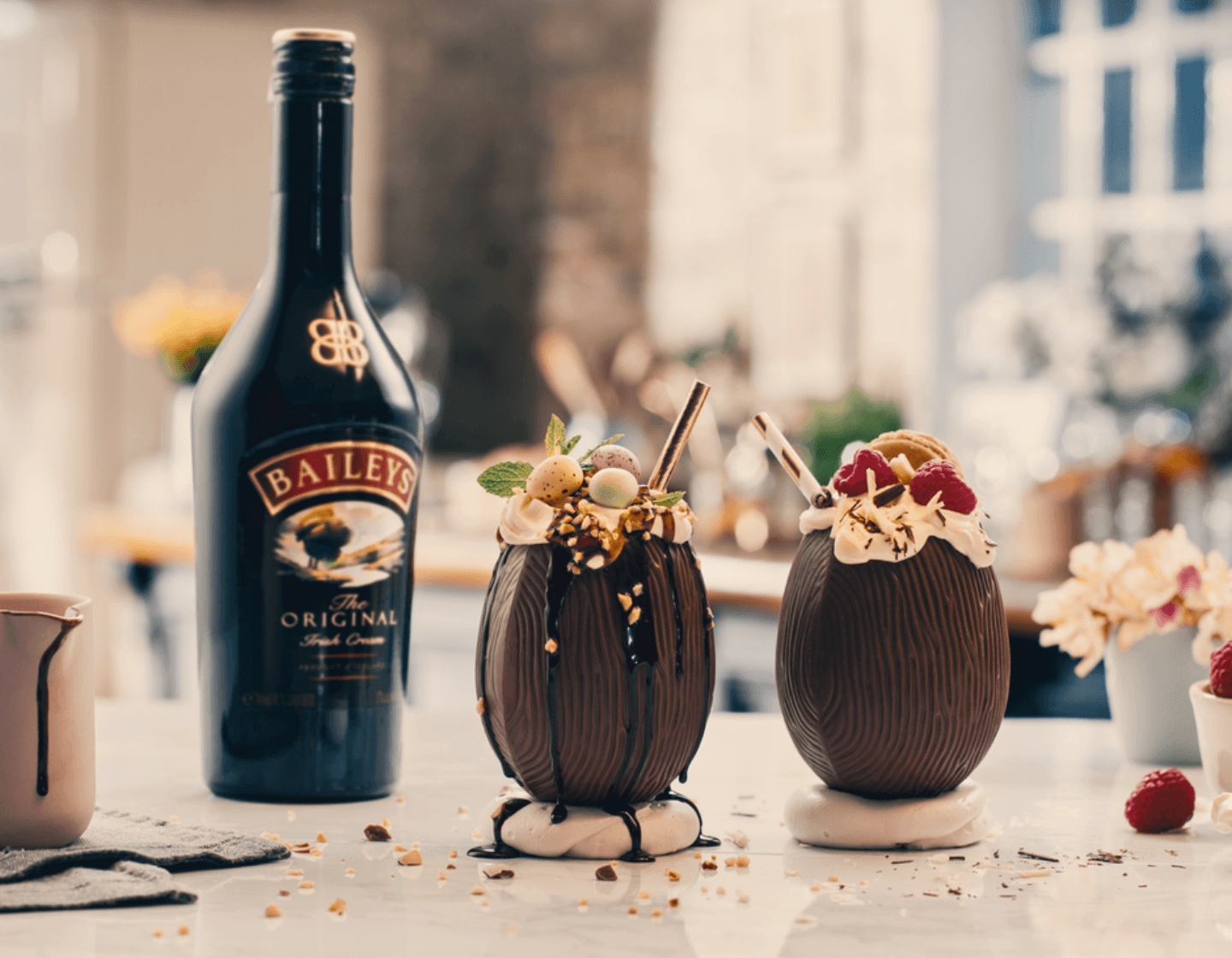Garrafa de baileys com dois serviços ao lado em um fundo desfocado