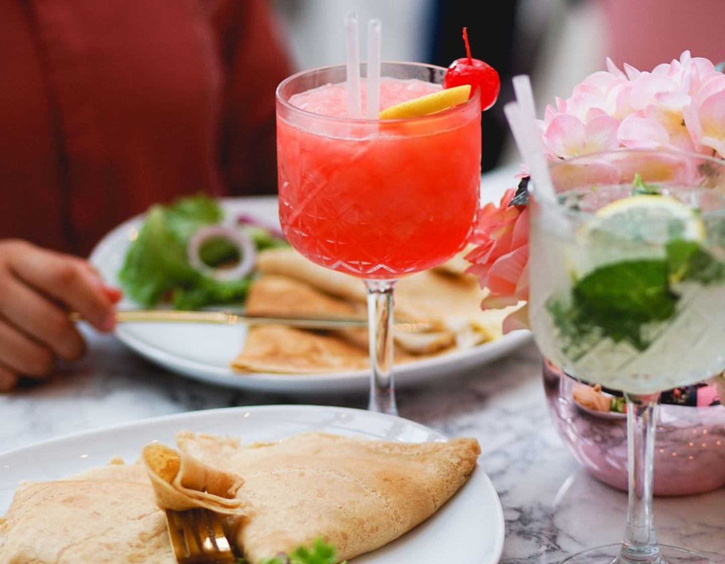 Two cocktails served with food 