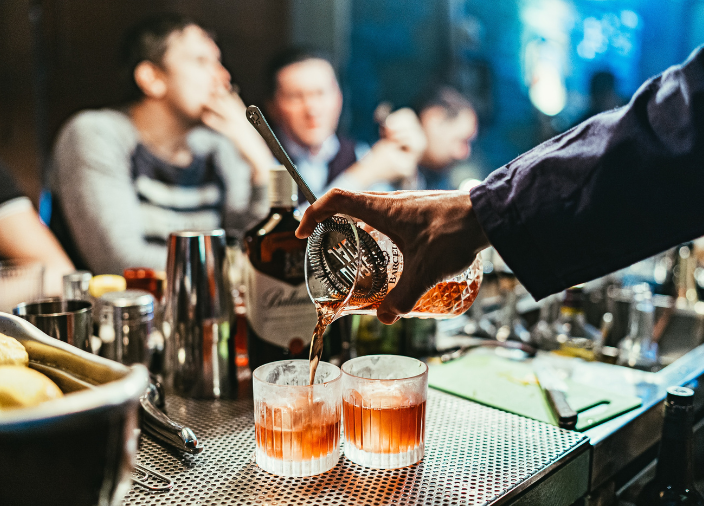Bartender pouring two cocktails 