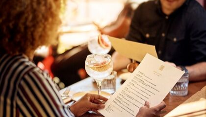  Imagem de um casal de clientes segurando um menu 