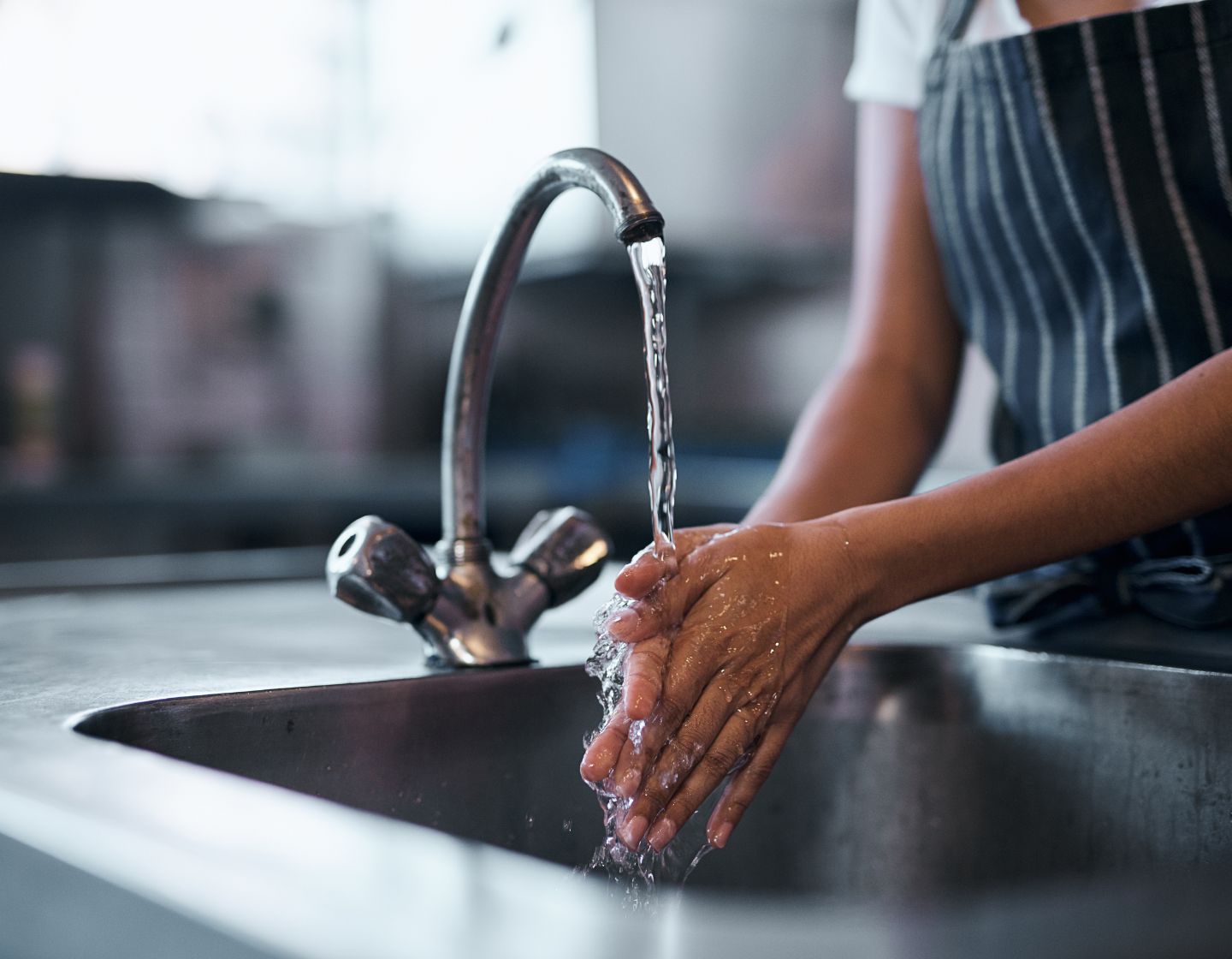 Barkeeper wäscht seine Hände am Waschbecken