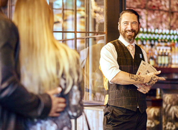 Man greeting guests at entrance of venue