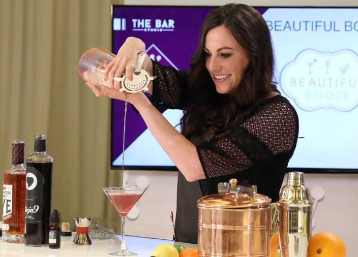 Natalie Migliarini colando un cóctel de una coctelera