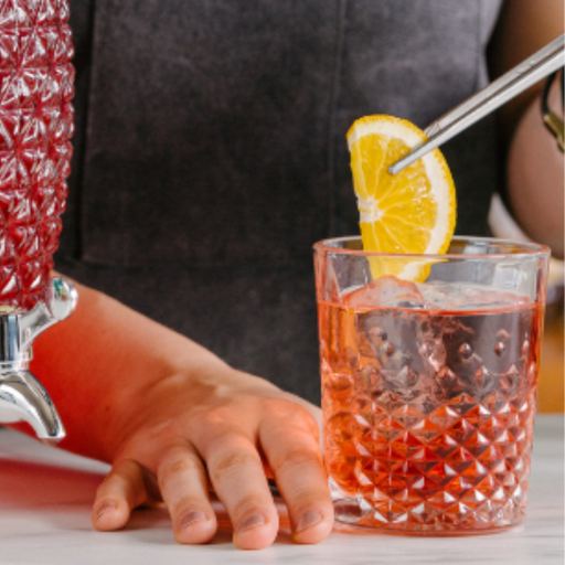 Bartender using lemon garnish to create the perfect red coloured cocktail