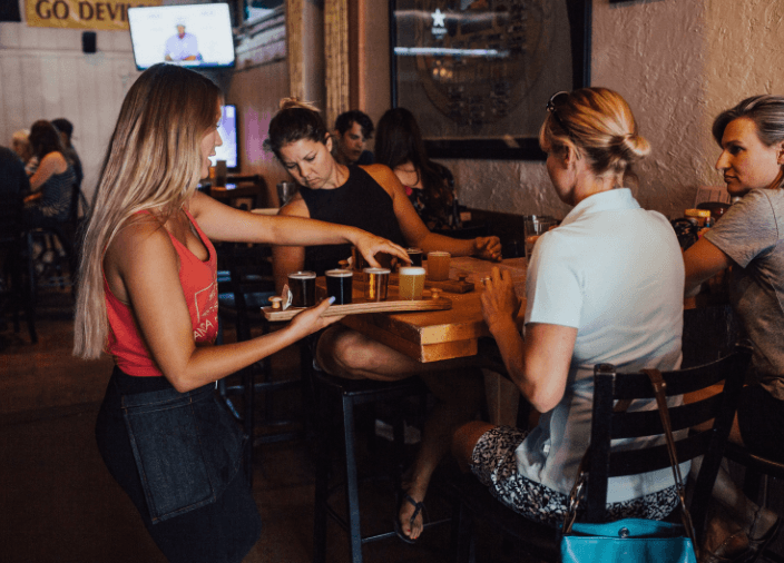 Bartender serving drinks to table