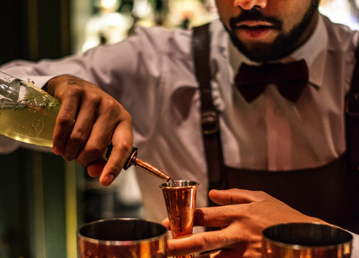 Bartender pouring measure into jigger