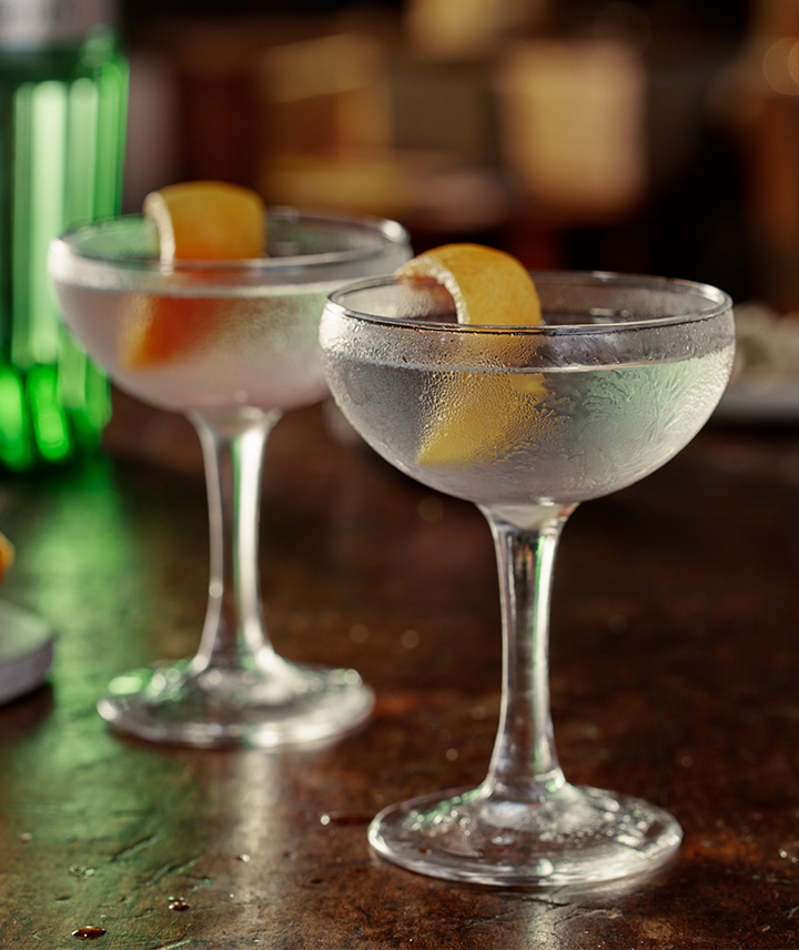 2 Cocktails in coupe glasses with lemon garnish 
