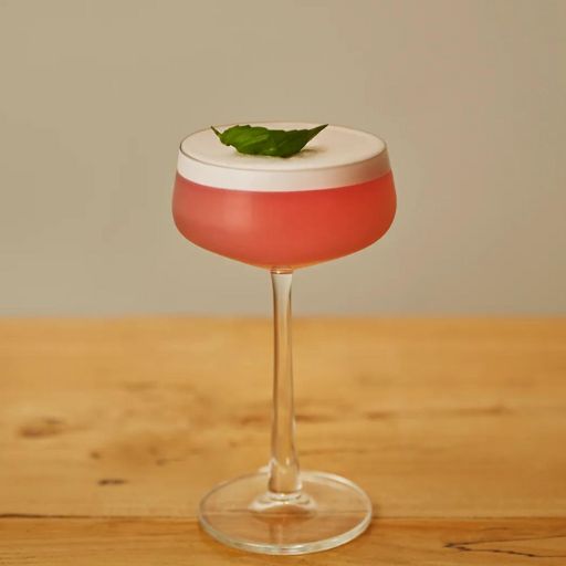 Coctel sin alcohol servido en una copa de Martini de color rojo