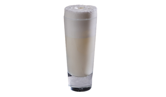 Copo alto contendo um coquetel opaco em tom branco cremoso. A bebida é finalizada com uma espessa e texturizada camada de espuma branca que ultrapassa levemente a borda do copo. Fundo branco isolado.