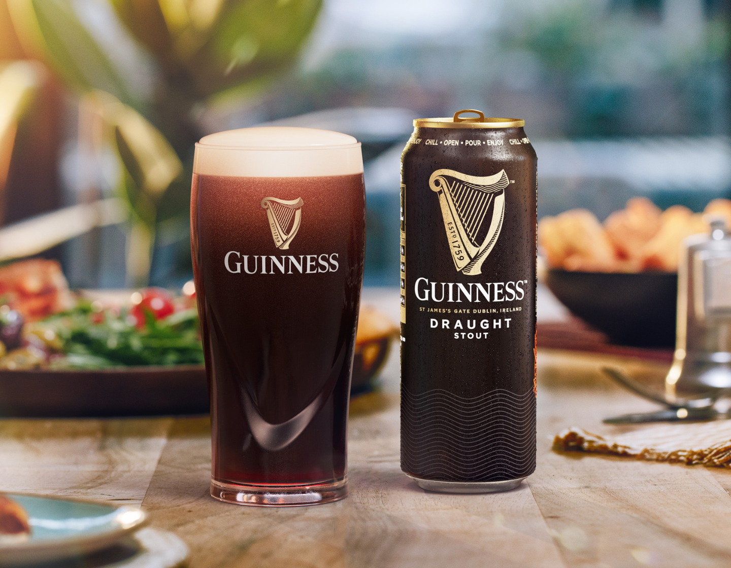 A can of Guinness beer next to a pint glass. 