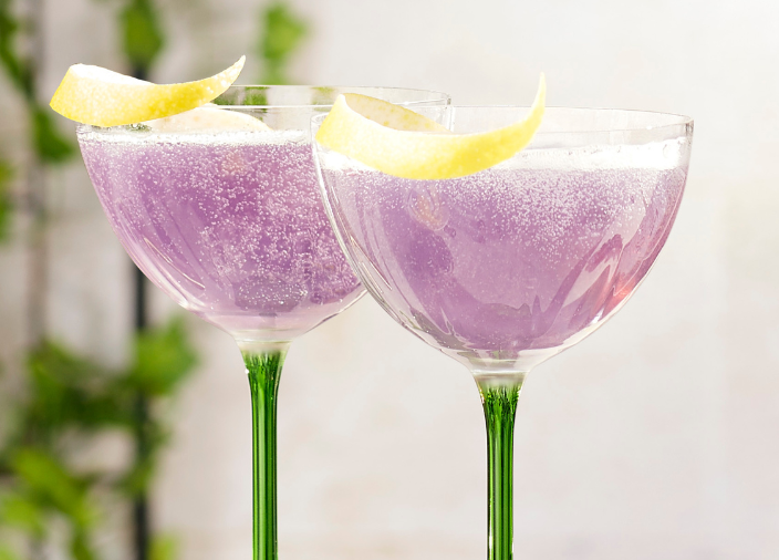Tanqueray Royal French 75 Cocktail of purple cocktail served in a coupe glass with lemon garnish 