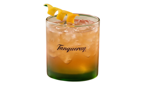 Copo baixo com base verde e logo da Tanqueray. Contém um coquetel refrescante em tom âmbar com bastante gelo, decorado com uma longa casca de cítrico em espiral repousando na borda superior. Fundo branco isolado.