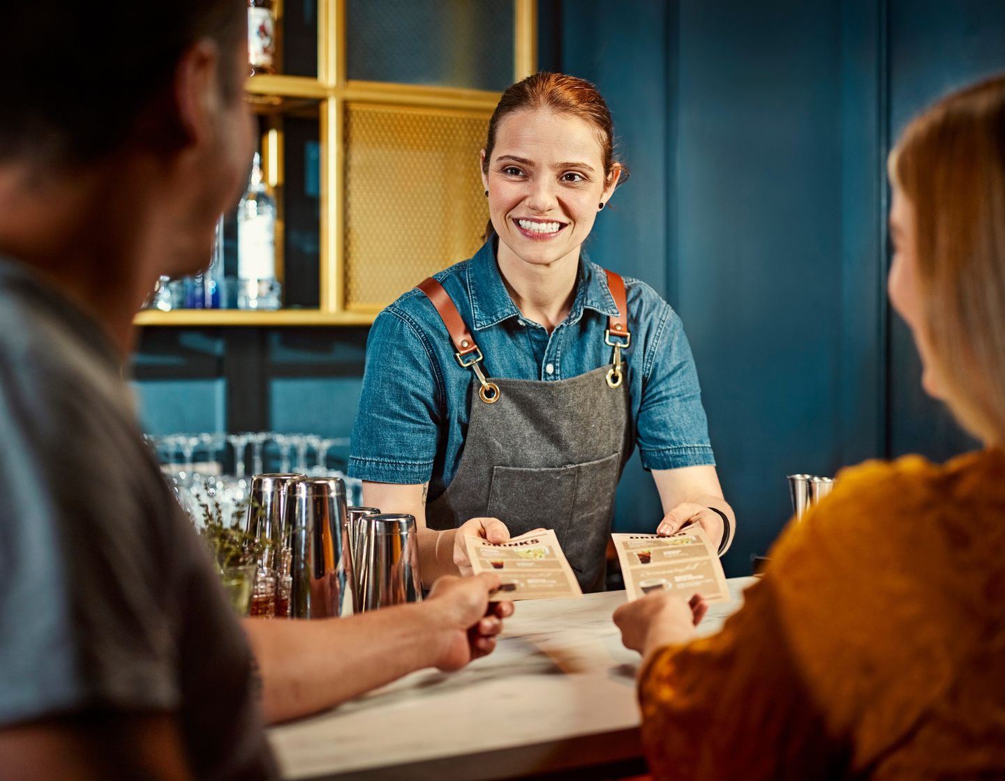 Bartenders welcoming customers with menus 