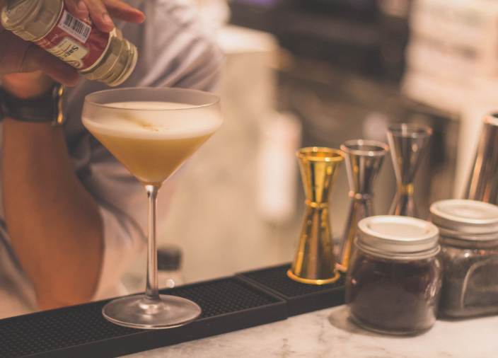 Bartender pouring spices into cocktail 