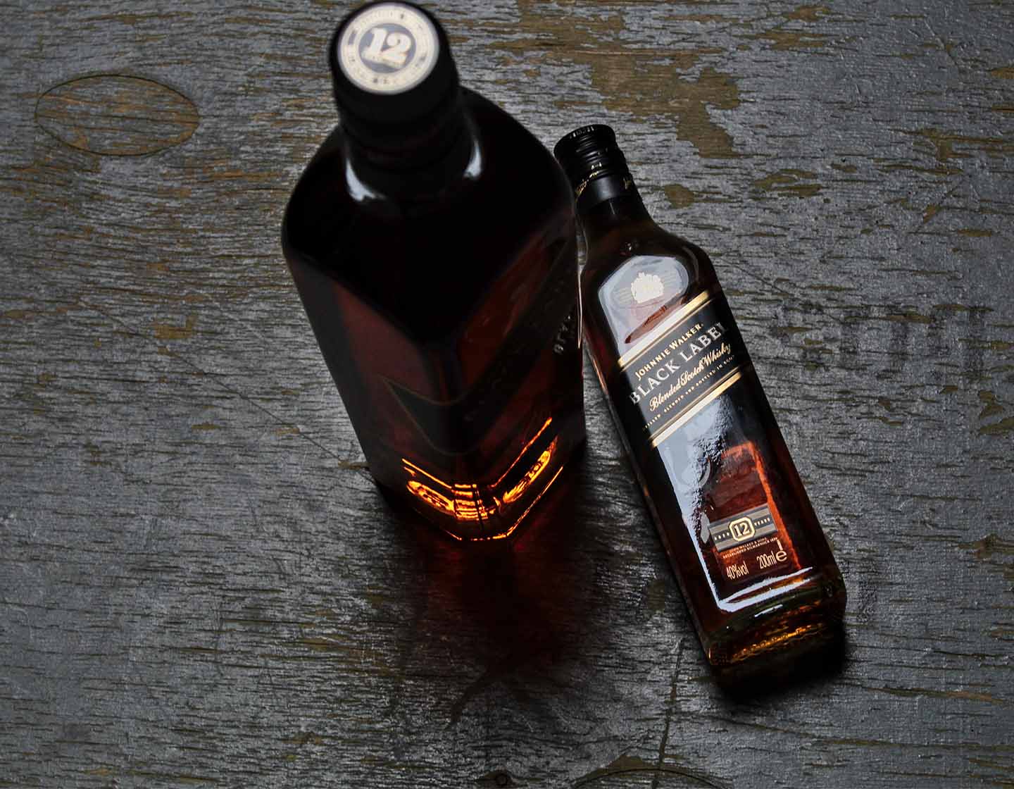 Dos botellas de Johnnie Walker Black Label. Uno de pie y otro acostado.