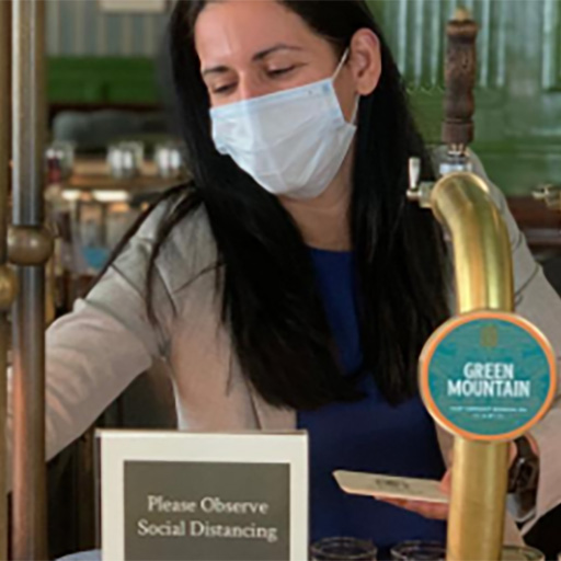 Bartender with mask serving a customer