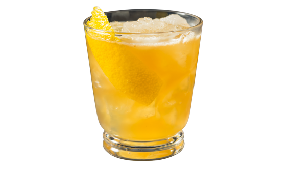 Copo baixo contendo um coquetel refrescante amarelo-alaranjado com gelo. Uma casca grossa de limão siciliano decora a lateral interna do copo, emergindo no topo da bebida. Fundo branco.