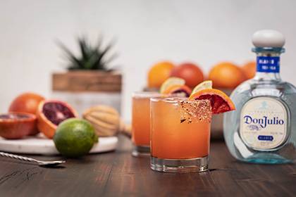 Two cocktails and a bottle of Don Julio