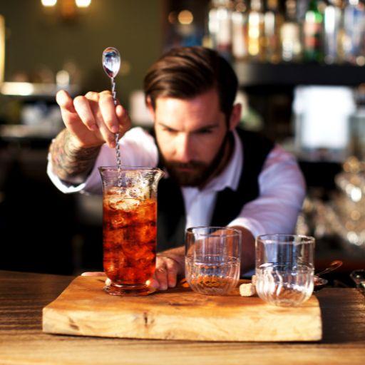 Man stirring drink in a bar. 