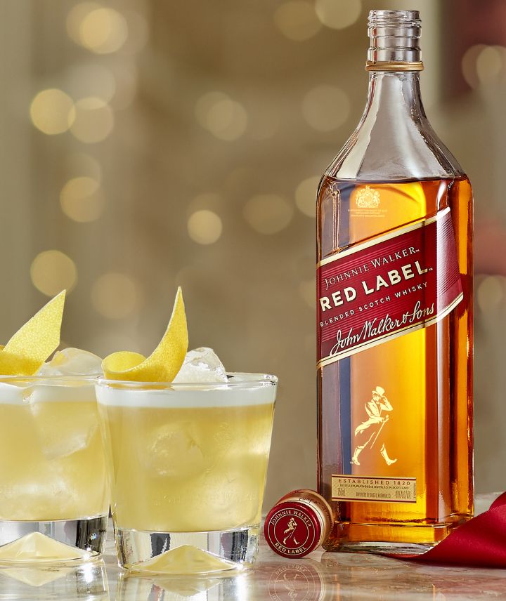 Eine Flasche Johnnie Walker Red Label neben 2 Red Label Cocktails