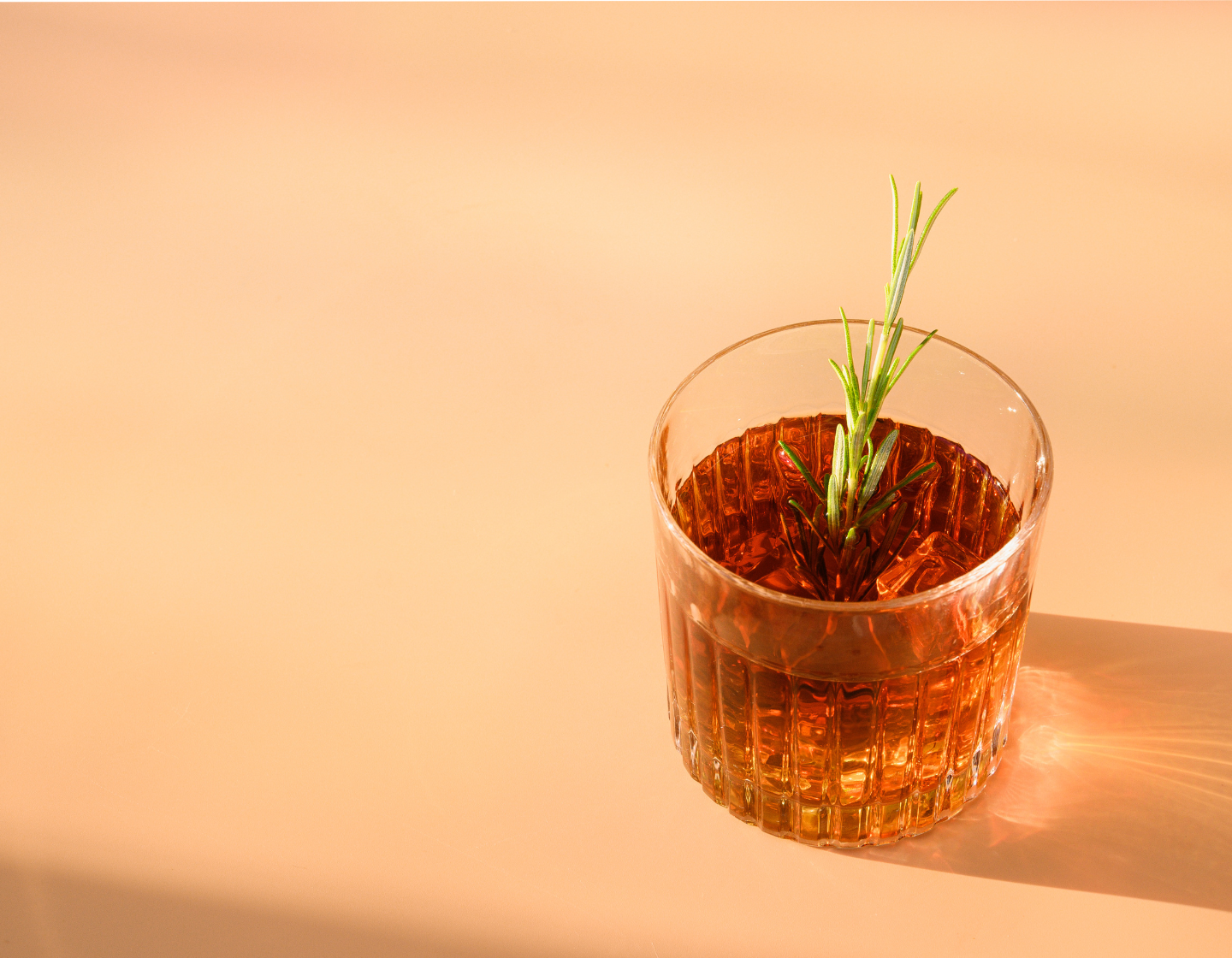 Vaso de Whisky con hielo y garnish de romero