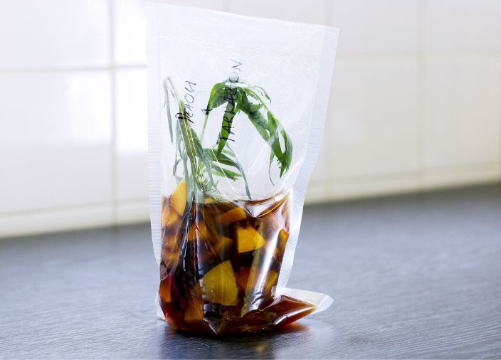 Frutas, álcool e folhas em infusão "sous vide" em um saco.  