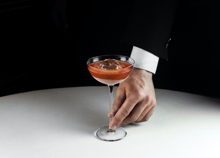Hand holding a cocktail at table 