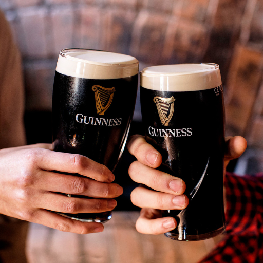 Hände, die zwei Pint-Gläser Guinness anstoßen