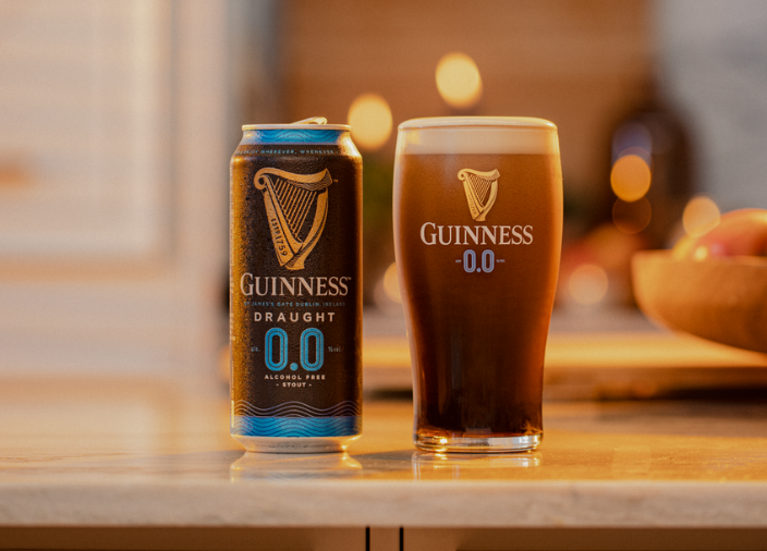 Can of Guinness 0.0 on countertop beside pint glass filled with Guinness 0.0 