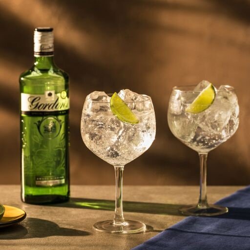 Dos copas de ginebra junto a una botella de Gordon's Gin