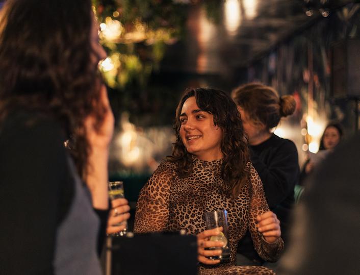Eine Barkeeperin auf dem World Bartender Day hält einen Drink in der Hand
