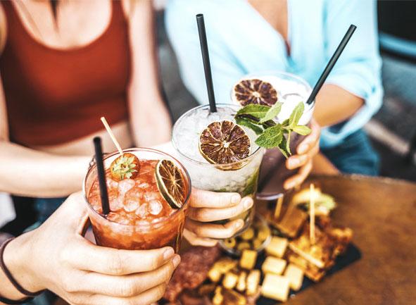 3 people holding cocktails