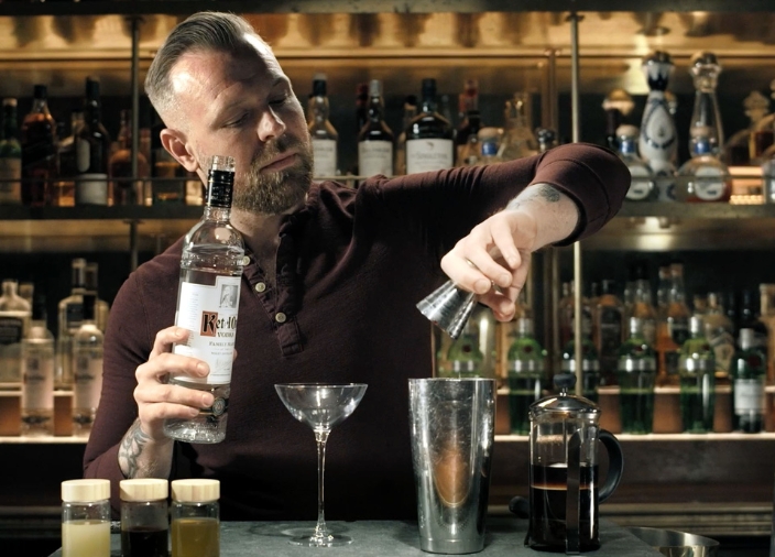 Bartender pouring a shot of Ketel One vodka into a cocktail shaker