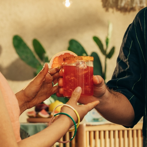 Blutorangen-Magarita im Glas mit Garnitur und Händen