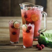 Punch cocktails in glasses next to a large pitcher 