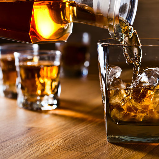 Whisky servido en un vaso con hielo 