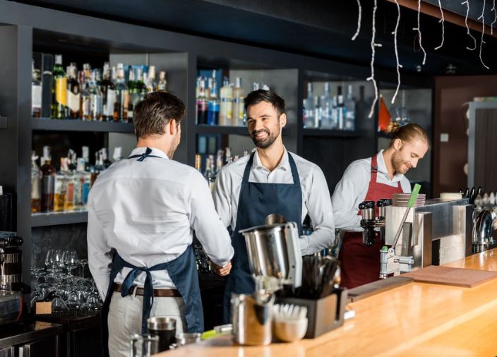 Un gerente de bar hablando con su equipo sonriendo
