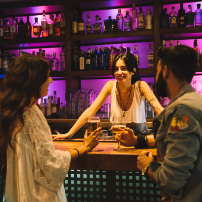 Bartenders atendiento en un bar lleno de gente