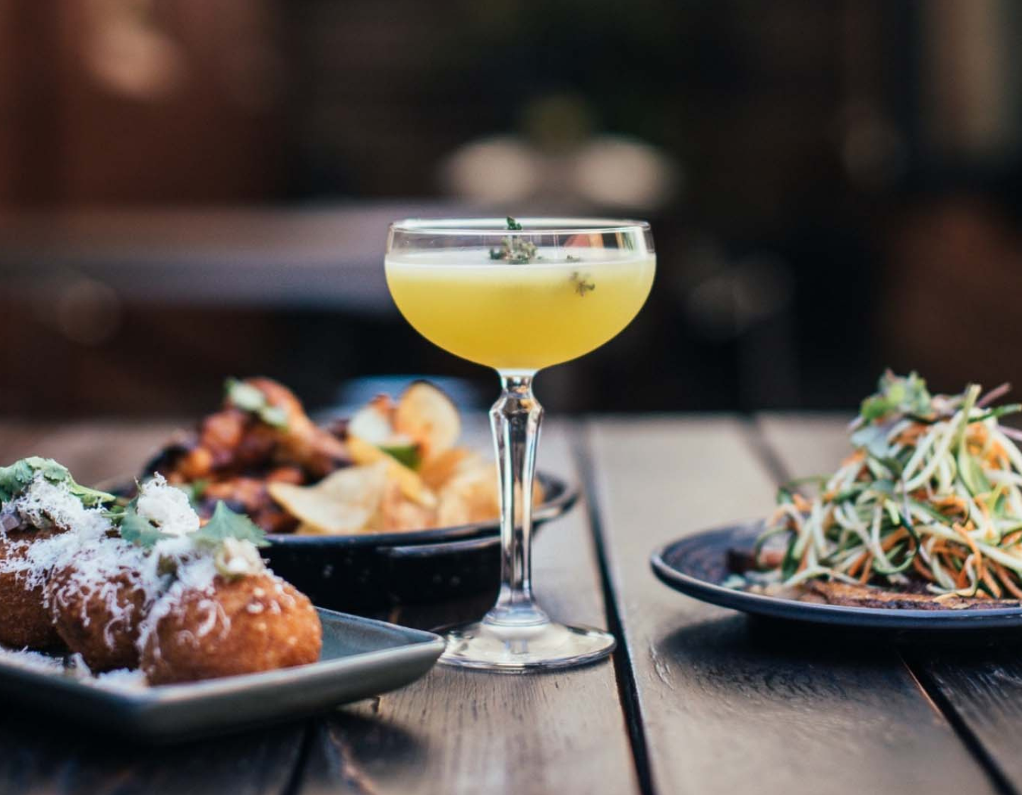 Cocktail surrounded by plates of food