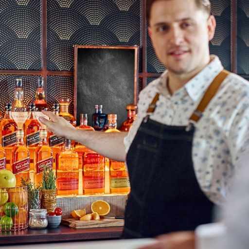 Bartender seleccionando una botella de la contrabarra