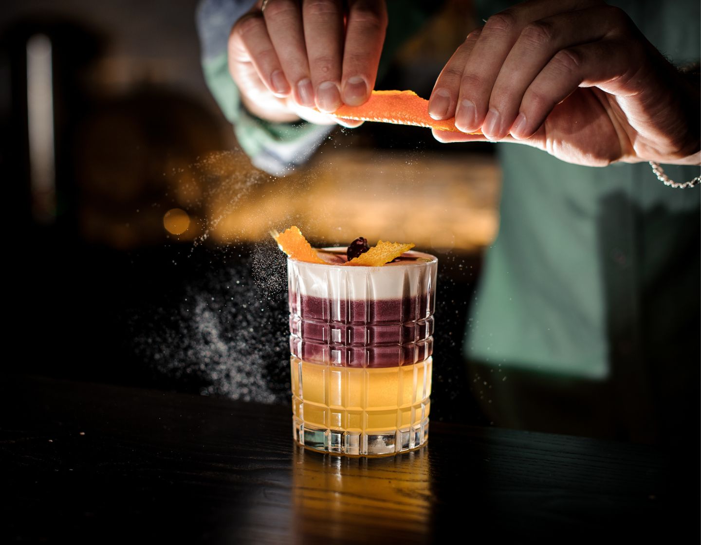 Bartender finishing up cocktail with garnish