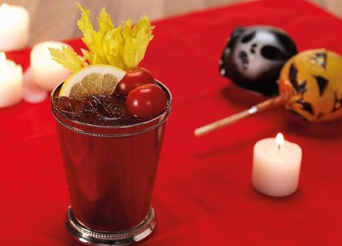 Halloween-Drink mit Süßigkeiten im Hintergrund