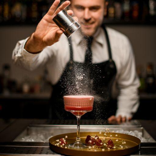 Bartender finishing up a high-end cocktail topping with garnish