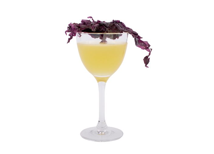 Un cóctel Salt Throne en una copa coupe con garnish de algas