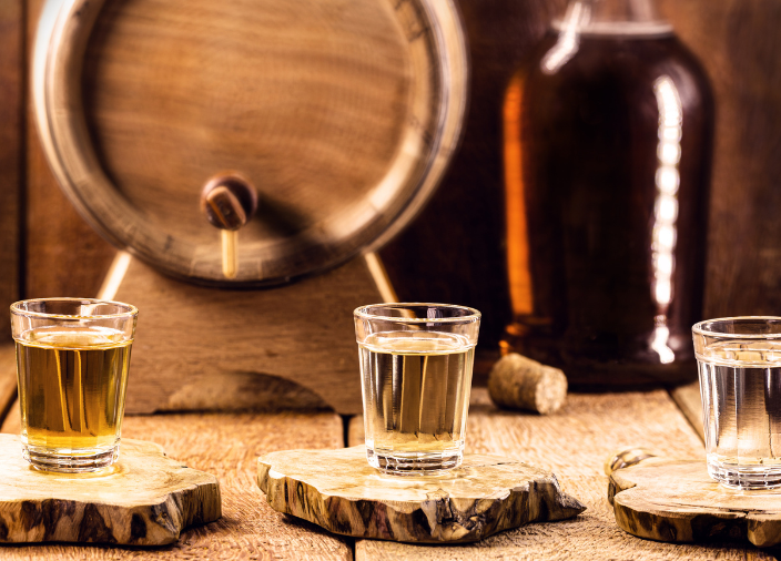 Imagem de um copo de cachaça ao lado de um barril