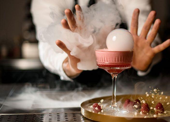 Ein Barkeeper mixt einen smoked Cocktail